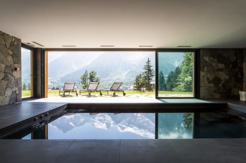 Indoor pool with mountain views at Le Chalet Mont-Blanc, Chamonix, featuring floor-to-ceiling windows overlooking alpine