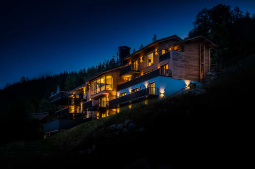 Le Chalet Mont-Blanc illuminé au crépuscule, niché dans une forêt de montagne près de Chamonix