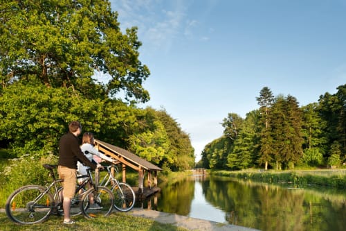 Un couple à vélo au bord du canal Ille-et-Rance