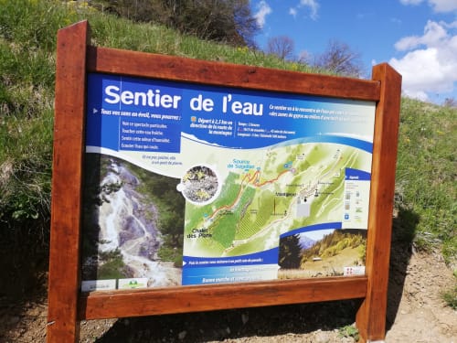 Sentier de l'eau hiking trail information sign in Aime la Plagne with map and waterfall details