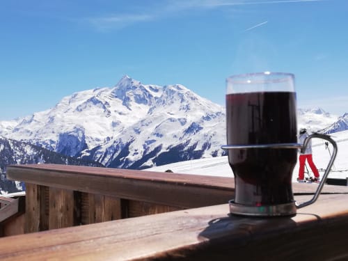 Mug of mulled wine overlooking snowy Alps at La Maison De L'Épine, Aime la Plagne ski resort
