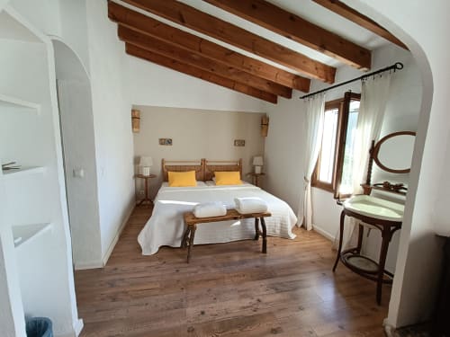 Habitación doble Xaloc Superior en Petit Hotel Sa Plana, Estellencs, con vigas de madera, vistas al jardín y mobiliario rústico