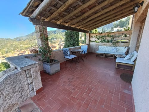 Terraza Mestral del Petit Hotel Sa Plana, Estellencs - pérgola de madera, zona de descanso con vistas a la montaña