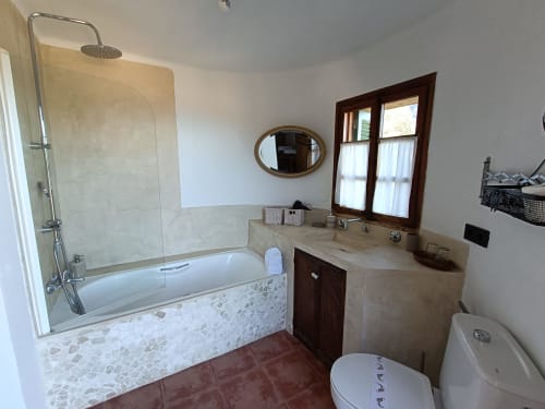 Baño luminoso en habitación Mestral de Petit Hotel Sa Plana, Estellencs, con bañera, ducha, tocador y vistas al mar