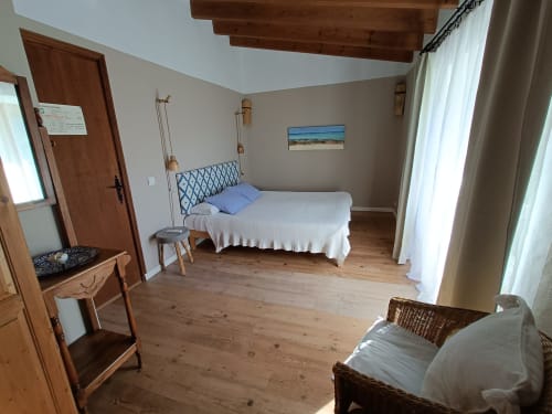 Habitación doble Llebeig en el Petit Hotel Sa Plana de Estellencs con vistas al mar, vigas de madera y cuadros de paisaje costero
