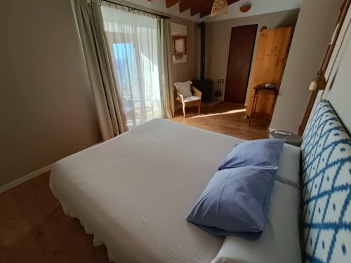 Amplio dormitorio doble con vistas al mar en Petit Hotel Sa Plana en Estellencs, con ropa de cama moderna y terraza privada
