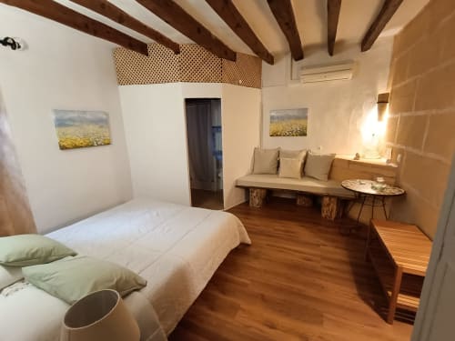 Ponent room at Petit Hotel Sa Plana in Estellencs with bed, sofa, wooden beams and garden view