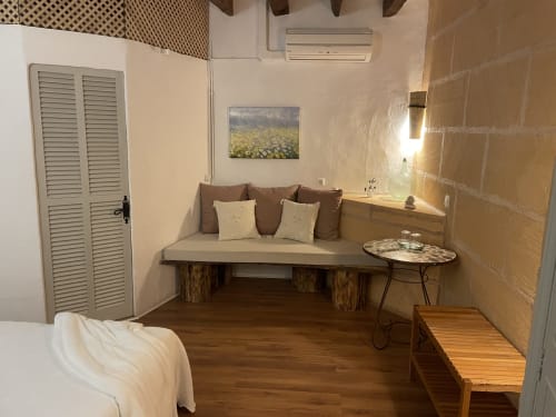 Cozy Ponent room at Petit Hotel Sa Plana in Estellencs with wooden bench seating, garden artwork, and modern amenities