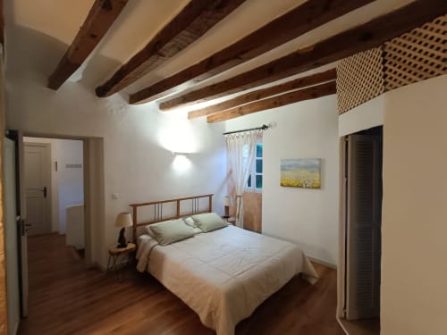 Ponent room at Petit Hotel Sa Plana, Estellencs - double bed with wooden beams, garden view window