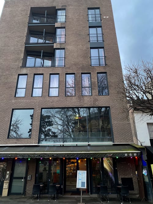 Façade de l'hôtel Chambre Pasteur à Montreuil avec briques, balcons et devanture au rez-de-chaussée