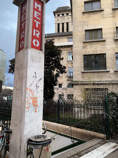Signalétique du métro devant l'hôtel Chambre Pasteur à Montreuil, France, avec bâtiment historique en pierre et rampes en fer