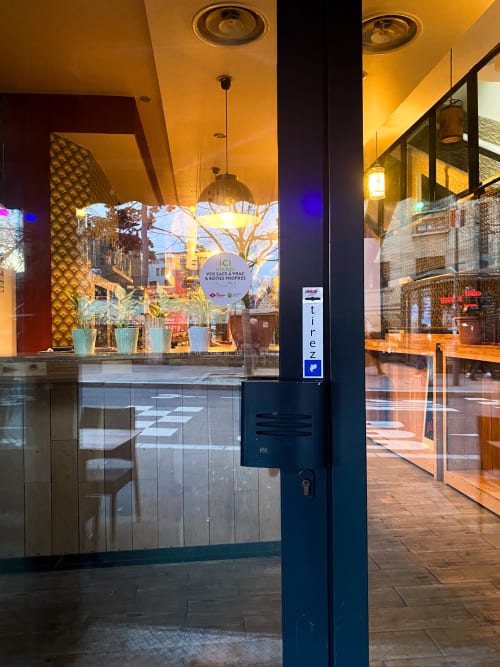 Entrée de l'hôtel Chambre Pasteur à Montreuil avec vitrine illuminée, portes vitrées et façade moderne