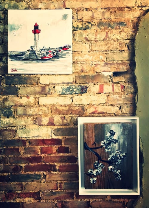 Exposition d'art côtier à L'Ermitage B&B à Saint-Vaast-la-Hougue avec tableaux thématiques marins sur mur de brique