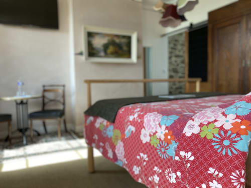Colorful floral bedspread in bedroom at L'Ermitage guesthouse, Saint-Vaast-la-Hougue