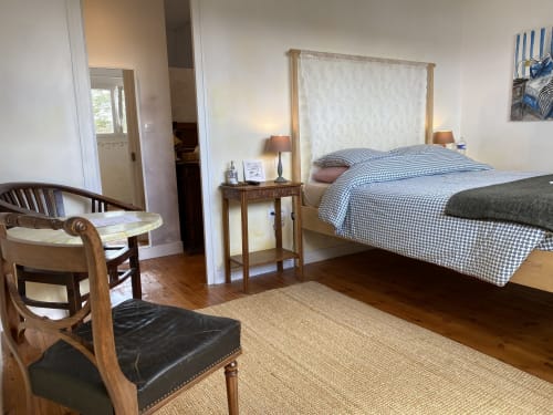 Spacious bedroom at L'Ermitage B&B in Saint-Vaast-la-Hougue with canopy bed, wooden furniture, and nautical décor