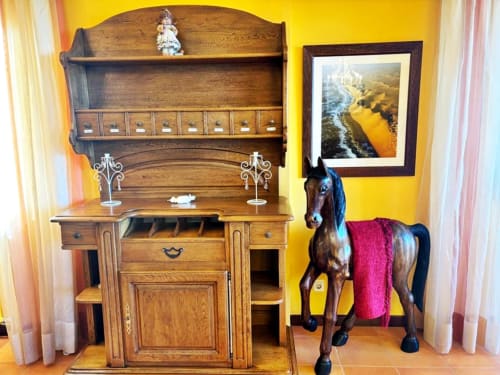Muebles de madera y estatua decorativa de caballo en la villa Vila Arume de Holibai, Baiona