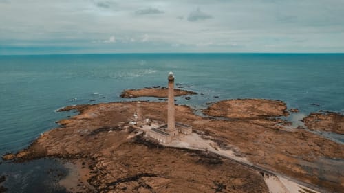 Historic lighthouse on rocky island off Saint-Vaast-la-Hougue coast, L'Ermitage BnB location in Normandy, France