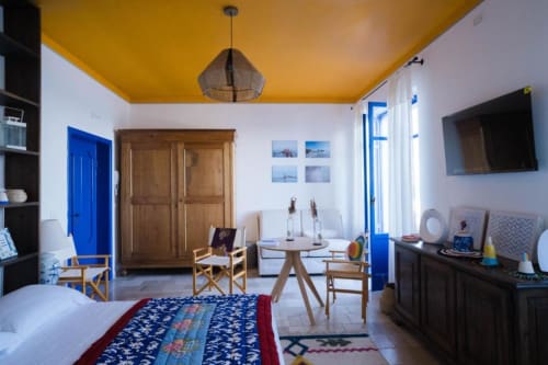Luminosa camera moderna al Le Vajane B&B a Torino di Sangro con soffitto giallo, accenti blu, mobili in legno e vista sul mare