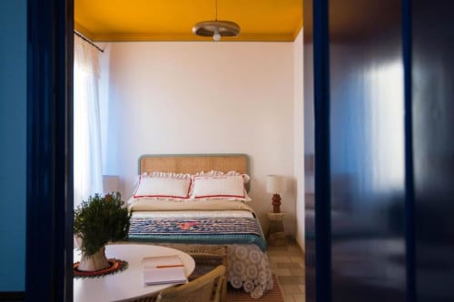 Camera luminosa al B&B Le Vajane a Torino di Sangro, con letto in rattan, biancheria a righe e vista sul giardino