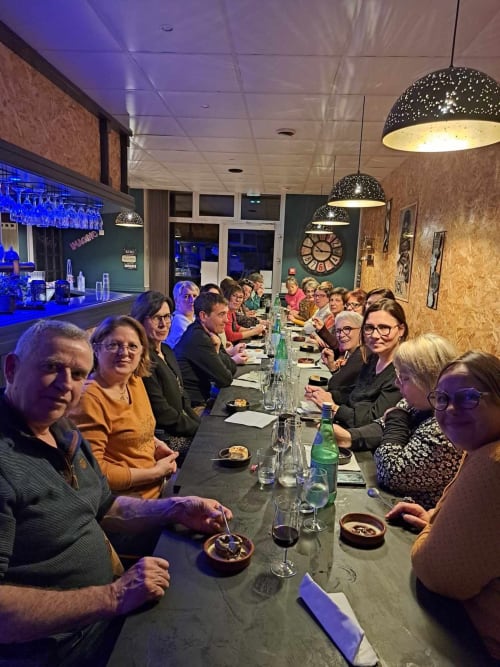 Événement de repas en groupe au restaurant Les Deux Porches à Verrières, convives assis à une table longue