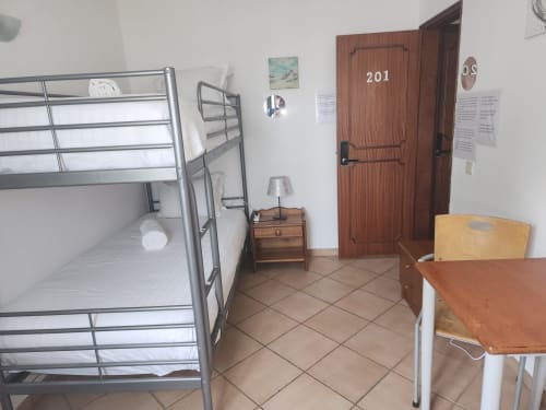 Duas camas beliches em um quarto de albergue econômico na Sunny House Lagos com acesso a banheiro compartilhado e móveis básicos