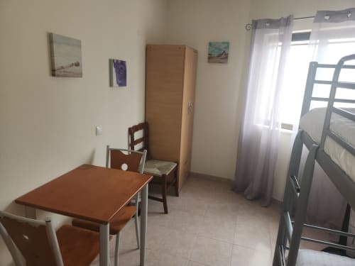 Quarto Econômico Twin no hostel Sunny House em Lagos com camas beliche, mesa de trabalho, guarda-roupa de madeira e banheiro compartilhado