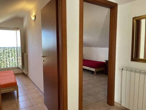 Corridoio dell'appartamento a Rigiariloo Home Apartments a San Giacomo degli Schiavoni con porte in legno e vista sulle montagne