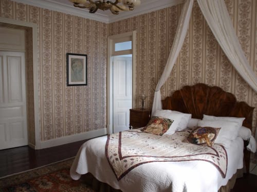 Chambre Buis élégante à la Villa Magnolia Parc de Montélimar avec papiers peints ornementés, lit en bois à baldaquin et vue sur la ville