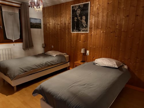 Chambre cosy du gîte Des Planchettes avec deux lits et décoration chaleureuse
