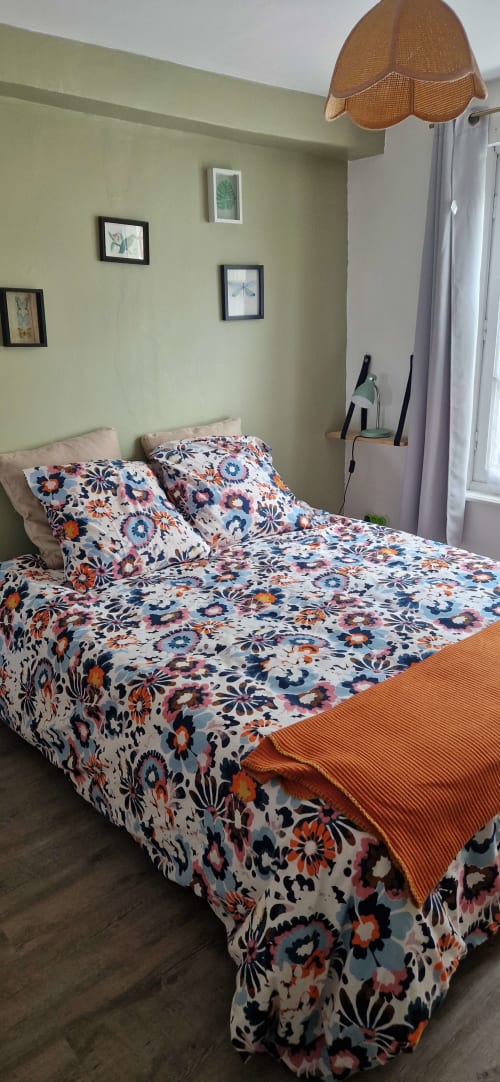Chambre 313 colorée avec literie florale à Vue D'ici B&B, Saint Valery sur Somme, murs vert pâle et luminaire en osier