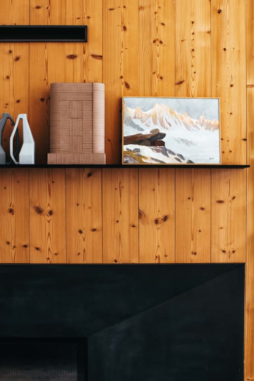 Étagère noire sur mur en bois présentant un tableau paysage montagnard, papier peint enroulé et décoration blanche au Chalet Mont-Blanc