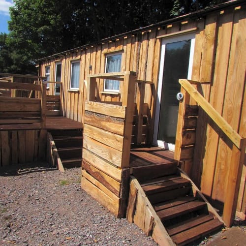 Wooden glamping lodge at Postwood Gardens Campsite, Kentisbeare with steps, railing, and windows