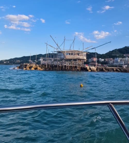 Vista da barca delle spiagge Le Vajane, lungomare di Torino di Sangro con boe colorate e edifici costieri