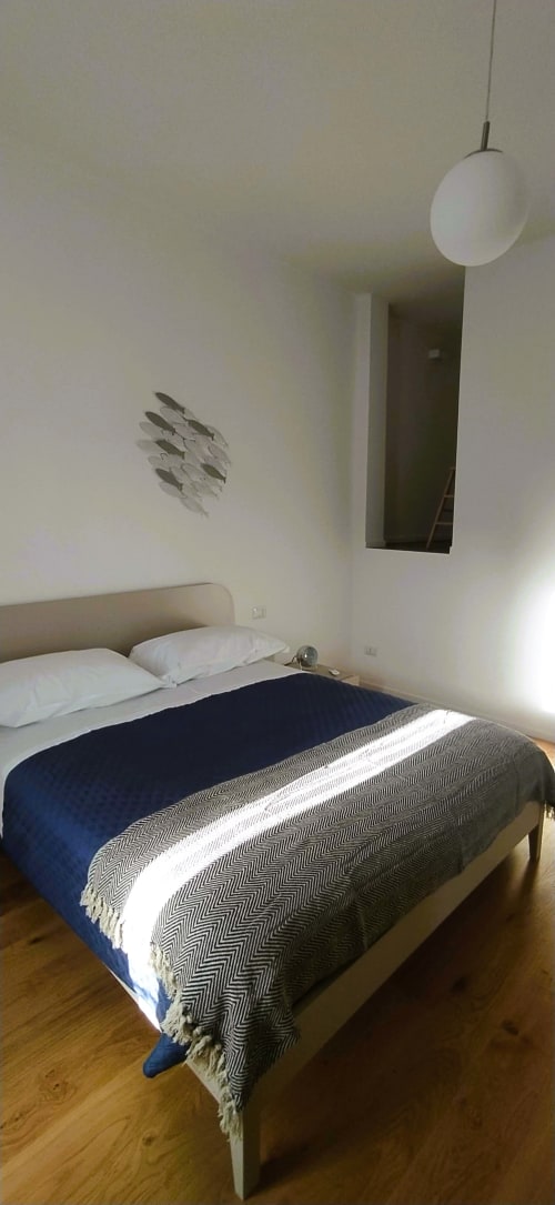 Camera da letto moderna dell'appartamento vacanze a Bari con letto, lampada a sospensione e quadri a parete