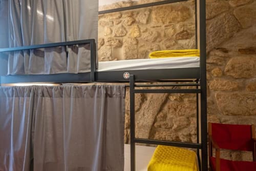 bunk beds in mixed dormitory at Albergue Santiago de Caminha hostel in Caminha, Portugal -Room in a mixed dormitory with air conditioning and Shared bathroom with shower. Tiled floor. Max occupancy: 1 person. Caminho Português da Costa - Camino de Santiago. Coastal way Senda Litoral