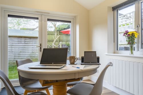 A versatile dining room creating a serene workspace at Meadow Rise, a delightful Cornish holiday property situated in St Columb Major, Cornwall. Featuring a spacious layout with ample natural light, this cozy area is ideal for remote work or creative endeavors. Enhance productivity while immersed in the serene surroundings of the Cornish countryside.