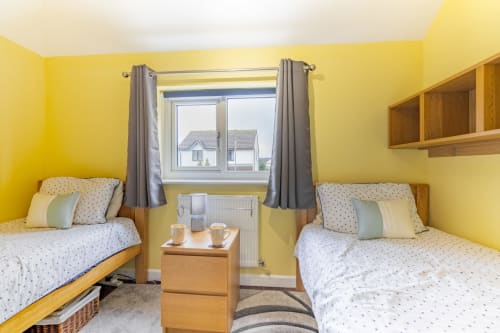 A charming twin bedroom at Meadow Rise, a lovely Cornish holiday property situated in the tranquil village of St Columb Major, Cornwall. Perfect for families or friends traveling together, this cozy room features comfortable beds and cheerful decor. Experience a restful night's sleep surrounded by the beauty of the Cornish countryside, ensuring a delightful stay for all guests.