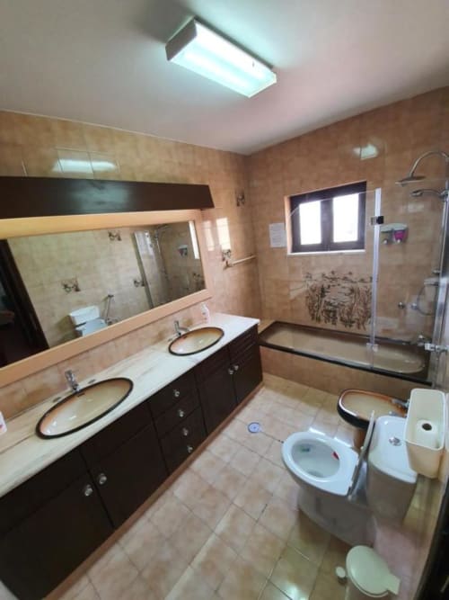 Modern shared bathroom at Ocean View Lagos hostel in Portugal with double sink vanity, toilet, and walk-in shower
