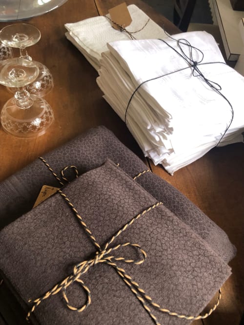 Élégante mise de table au Domaine de l'Ocrerie avec nappes pliées, verres à vin et serviettes nouées de doré à Pourrain