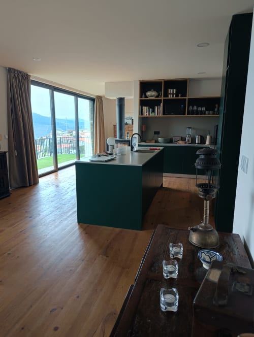 Cozinha moderna com ilha verde e área de refeições com vista para o rio Douro no Vale do Douro, a partir da varanda da Quinta do Fraguil
