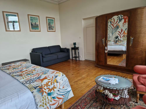 Spacious Camélia bedroom at Domaine de l'Oie Rouge with double bed, sofa, wardrobe, and Loire river view