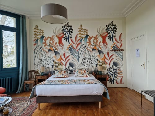 Camélia bedroom at Domaine de l'Oie Rouge with colorful botanical wall mural, wooden bed, pendant light, and Loire river view