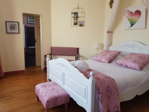 Romance room at Domaine de l'Oie Rouge with white bed, pink decor, and garden views in Gennes-Val-de-Loire