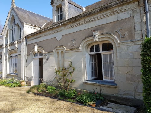Stone exterior of Domaine de l'Oie Rouge B&B in Gennes-Val-de-Loire with arched windows and garden view