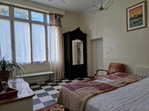 Coriandre bedroom at Domaine de l'Oie Rouge near Angers with twin beds, black wardrobe, windows, and checkered floor