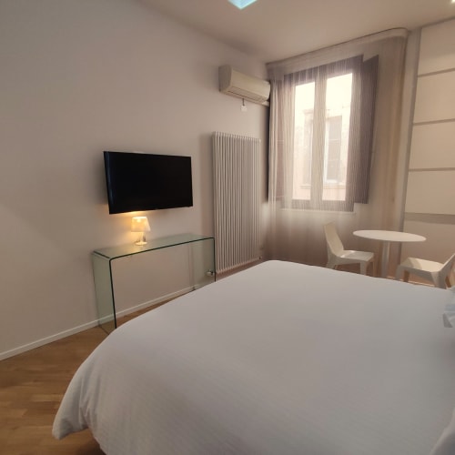 Modern junior suite at Stella CasaBono hotel in Sulmona with bed, flat-screen TV, and bright windows