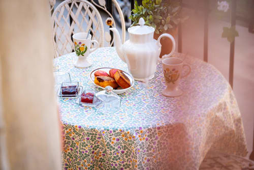 Elegant breakfast table at La Maison George with pastries, white pitcher, and floral patterned tablecloth in Flavigny sur