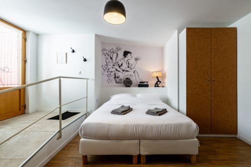 Logis Camille apartment at La Maison George with modern bed, cork wardrobe, and botanical wall art in Flavigny sur Ozerain