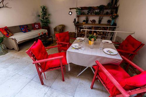 Dining area in Logis Camille apartment at La Maison George with red chairs and round table