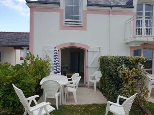 Terrasse face à la mer du Loc'Maria Belle Île en Mer avec mobilier blanc et murs recouverts de lierre